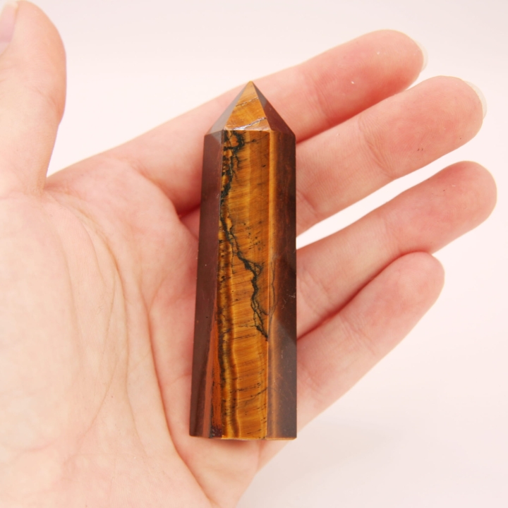 Polerowany obelisk z naturalnego tygrysiego oka o złocisto-brązowej barwie.