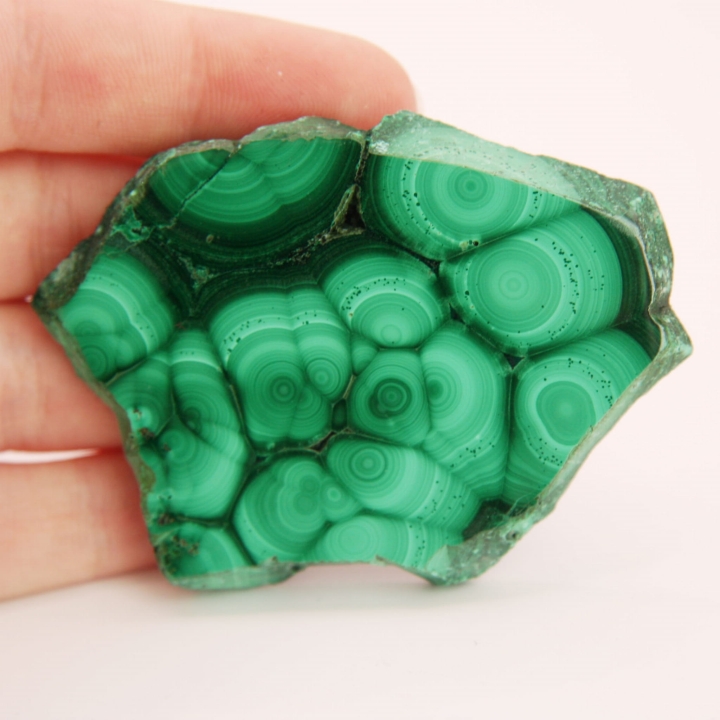 Dwustronnie polerowany plaster zielonego malachitu z widocznymi pasmami.