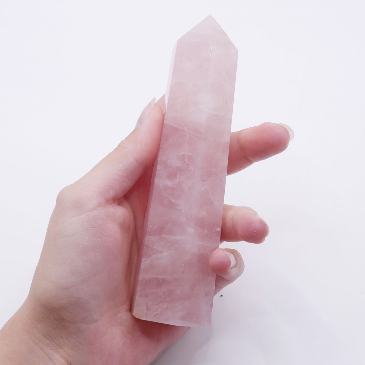 Polerowany szpic z różowego kwarcu jako element dekoracyjny wnoszący do wnętrza energię miłości.