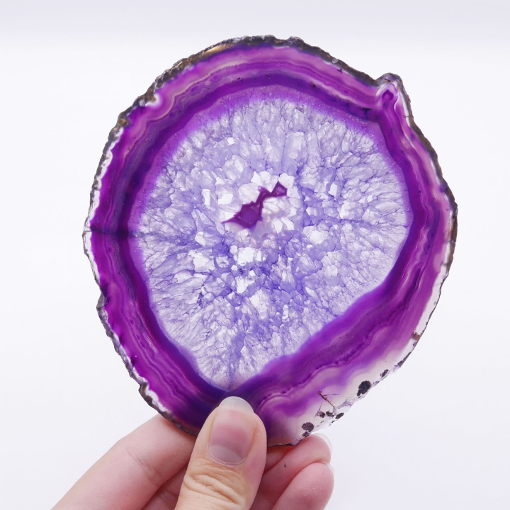 Dwustronnie polerowany plaster fioletowego agatu z surowymi krawędziami na białym tle.