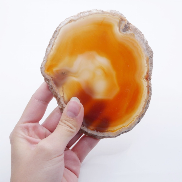 Dwustronnie polerowany plaster z agatu w ciepłych odcieniach pomarańczu.