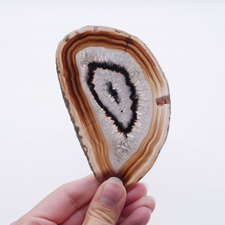 Zbliżenie na gładką, lustrzaną powierzchnię czarnego plastra agatu.