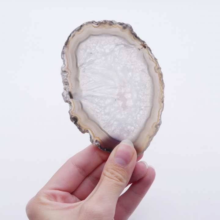 Zbliżenie na lustrzany połysk gładkiej powierzchni czarnego plastra agatu.