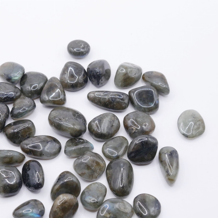 Gładkie, ciemnoszare otoczaki z labradorytu z widocznymi niebieskimi i złotymi refleksami.