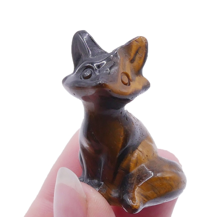 Ręcznie rzeźbiona figurka lisa z naturalnego tygrysiego oka na białym tle.