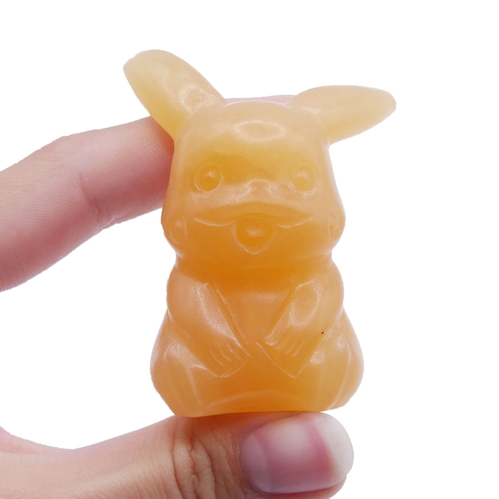 Polerowana figurka Pikachu z pomarańczowego kamienia o ciepłej barwie.