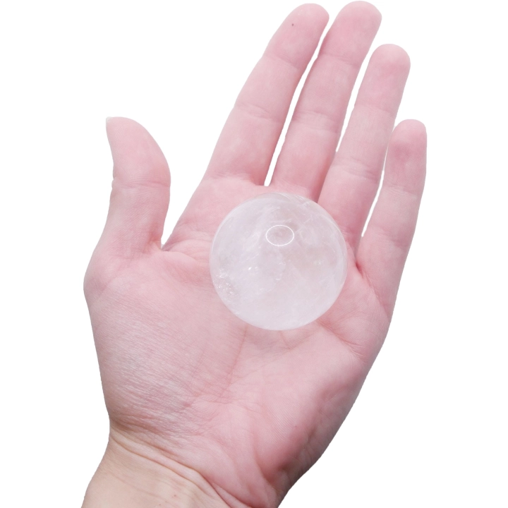 Unikatowa, polerowana kula z naturalnego kryształu górskiego na białym tle.