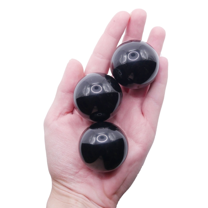 Zbliżenie na powierzchnię kuli z czarnego onyksu, podkreślające jej głęboką, jednolitą czerń.