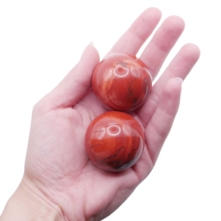 Gładka, polerowana kula z naturalnego czerwonego jaspisu na białym tle.