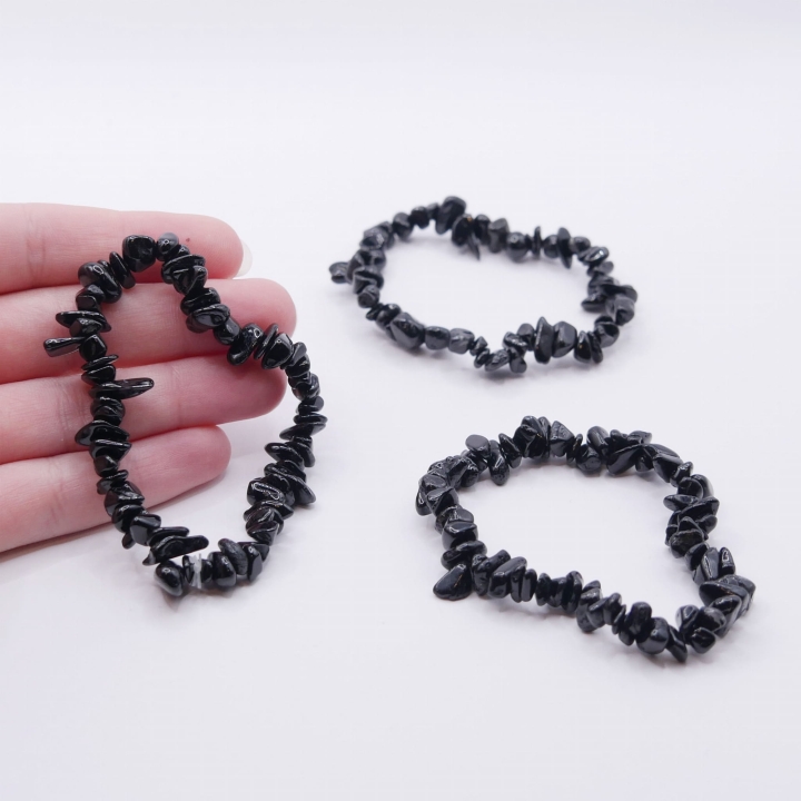 Zbliżenie na drobne, polerowane kamienie onyksu w bransoletce, ukazujące ich nieregularne kształty.