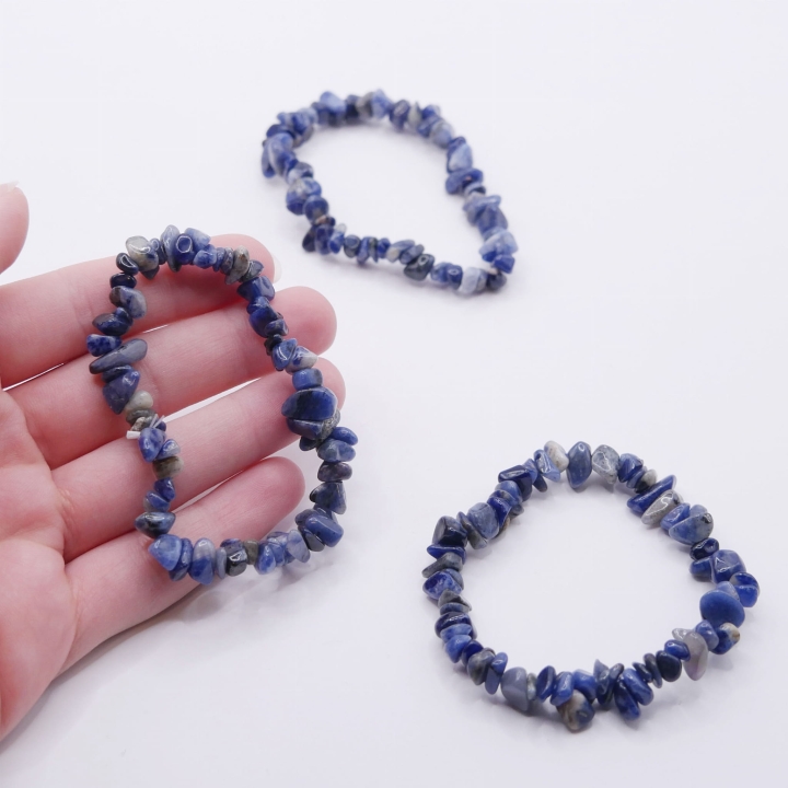 Zbliżenie na drobne, polerowane kamienie sodalitu, ukazujące ich niebieską barwę i białe żyłki.