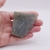 Fragment surowego labradorytu z polerowanym oknem ukazującym wewnętrzne piękno kamienia.