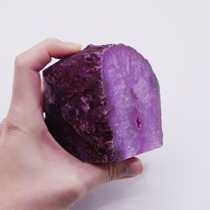 Zbliżenie na polerowany front różowego agatu, ukazujące jego wewnętrzne pasmowanie.