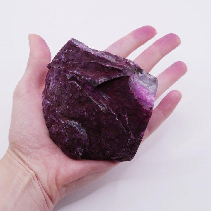 Kontrast między surową, naturalną fakturą a gładką, polerowaną powierzchnią różowego agatu.