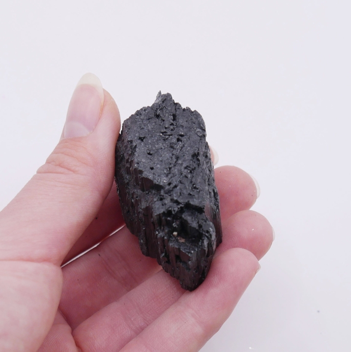 Fragment kryształu czarnego turmalinu z widocznymi, naturalnymi ścianami.