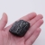 Minerał nr 055 o nieregularnym kształcie, prezentujący matową czerń i głębokie pęknięcia.
