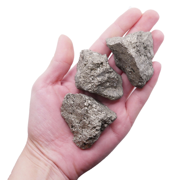 Surowa bryłka pirytu o metalicznym, złotym połysku na białym tle.