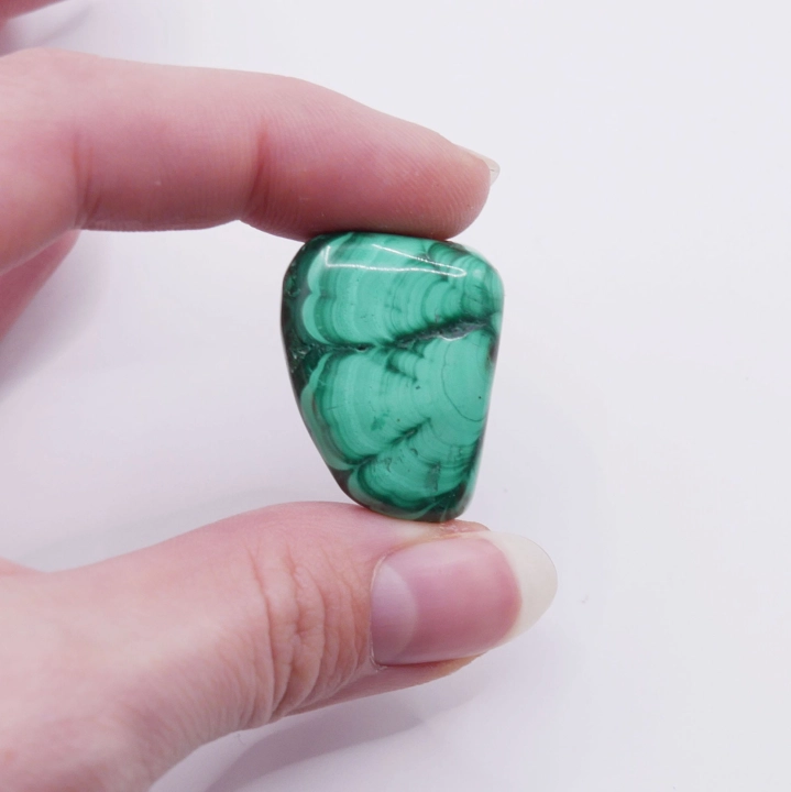 Zbliżenie na unikalne, naturalne wzory na powierzchni polerowanego malachitu.