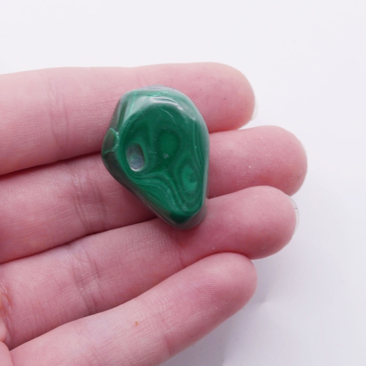 Zbliżenie na faliste pasma i wzory na otoczaku malachitu nr 027.