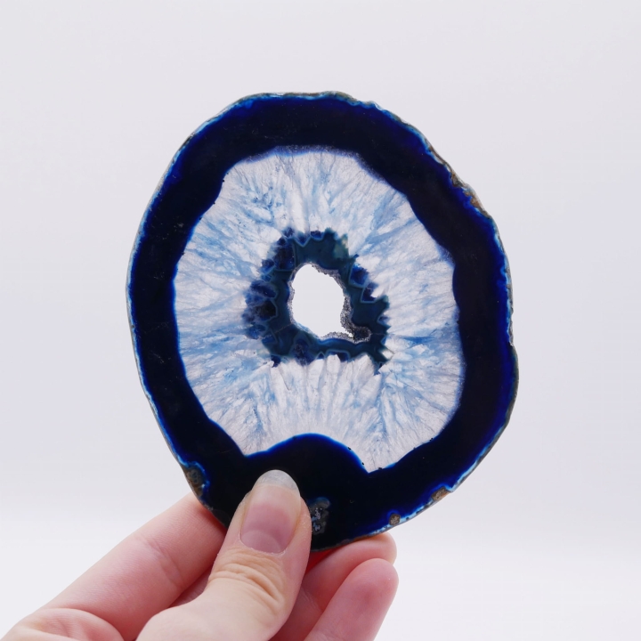 Dwustronnie polerowany plaster niebieskiego agatu o nieregularnym kształcie na białym tle.