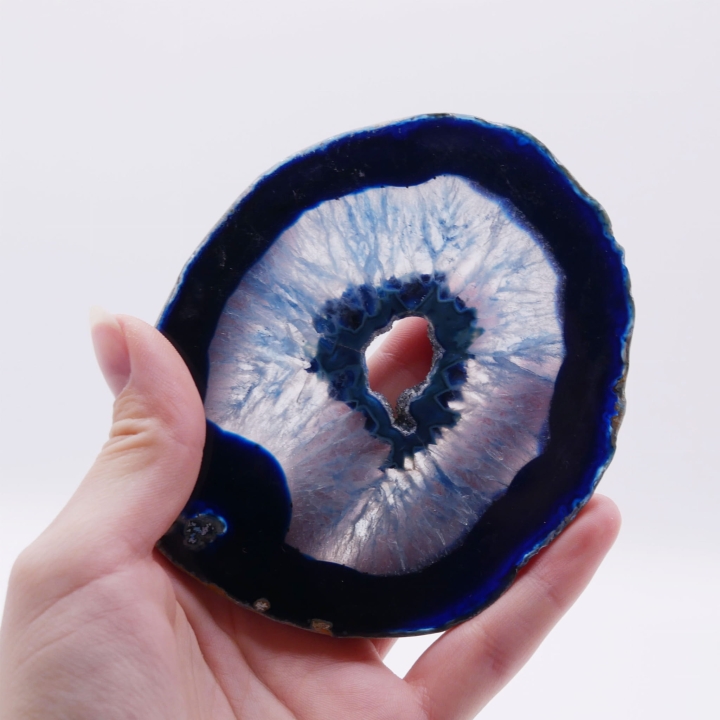 Zbliżenie na pasmową strukturę i odcienie błękitu wewnątrz plastra agatu.