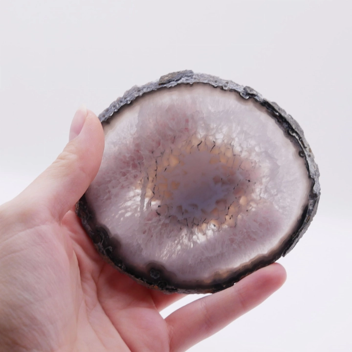 Dwustronnie polerowany plaster czarnego agatu o nieregularnym kształcie na białym tle.