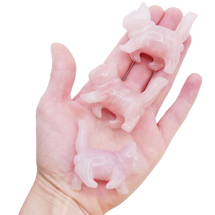 Ręcznie rzeźbiona figurka kota z naturalnego kwarcu różowego na białym tle.