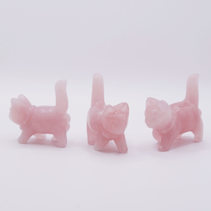 Figurka kota z kwarcu różowego trzymana w dłoni, ukazująca jej rozmiar.