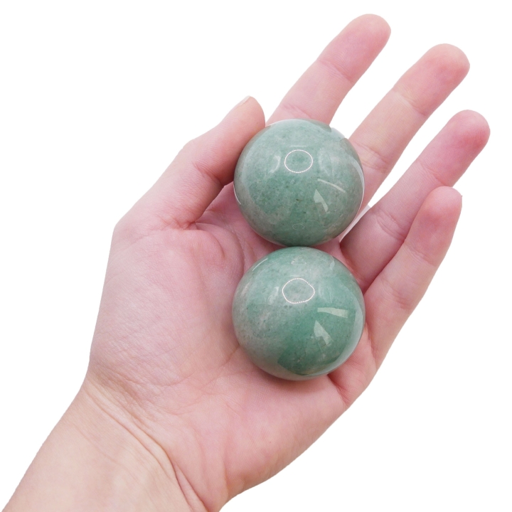 Polerowana kula z zielonego awenturynu o gładkiej powierzchni na białym tle.