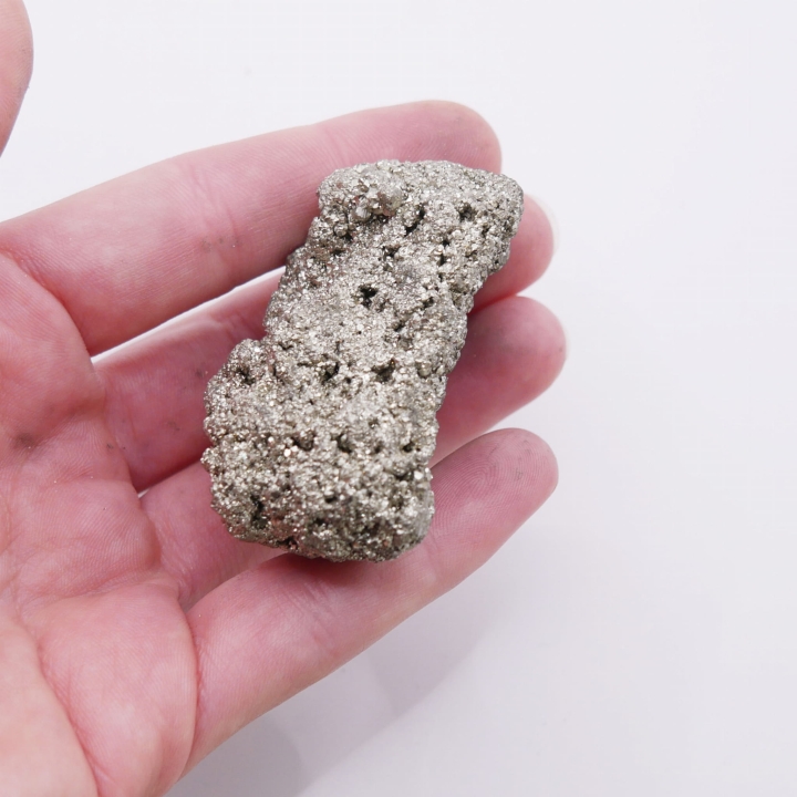 Masywny okaz pirytu odbijający światło, ukazujący metaliczny blask.