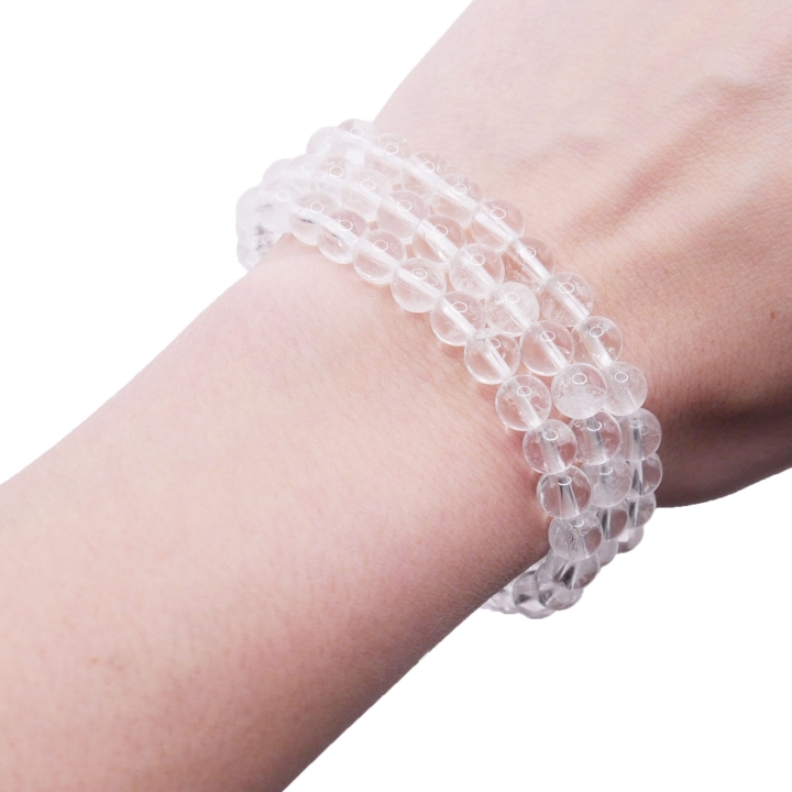 Bransoletka z naturalnego kryształu górskiego (kulka 6 mm) założona na nadgarstek.