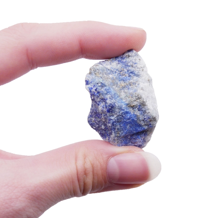Surowa bryłka lapis lazuli o nieregularnym kształcie na białym tle.