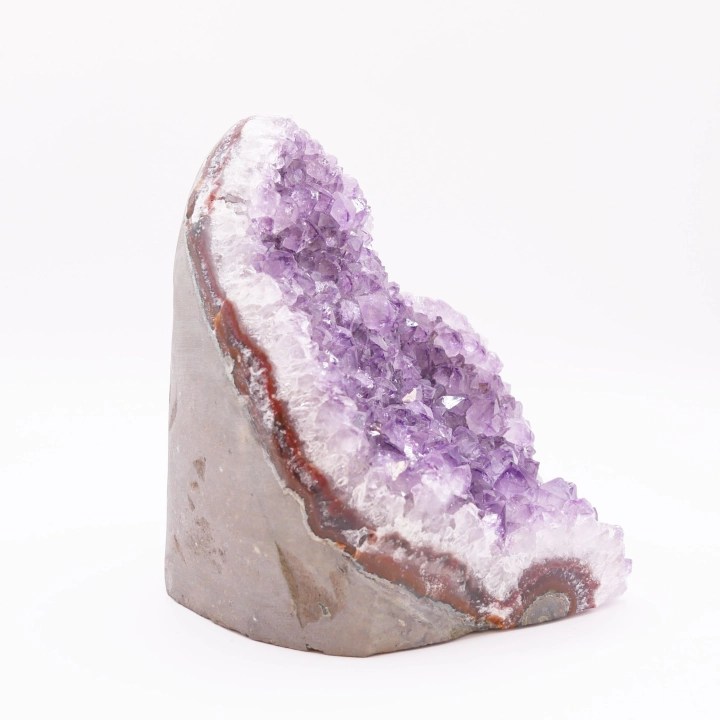 Boczny widok na geodę ametystową, ukazujący grubość skalnej matrycy i kryształy.