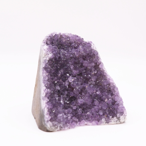 Zbliżenie na lśniące wnętrze ametystu kontrastujące z surową skałą na zewnątrz.