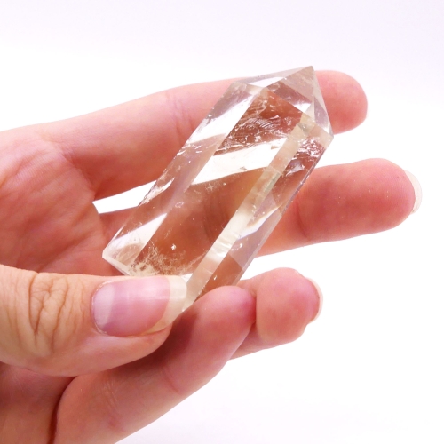 Gładki obelisk z cytrynu z widocznymi naturalnymi inkluzjami.