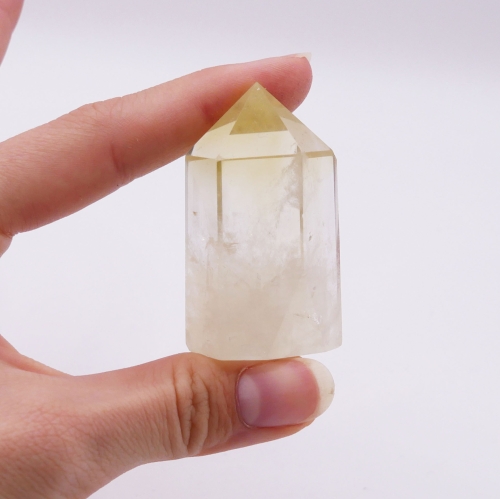 Polerowany obelisk z jasnego cytrynu o ostrym wierzchołku na białym tle.