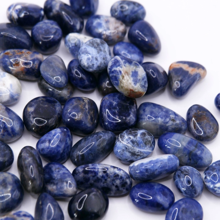 Polerowany kamień sodalitu o średnicy ok. 1 cm z naturalnym, kontrastowym wzorem warstwowym.