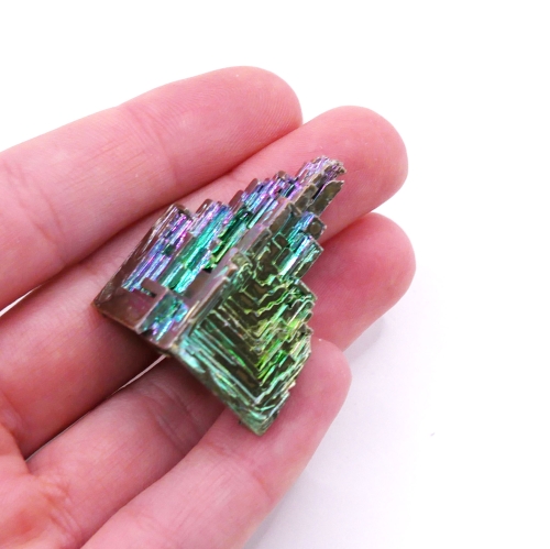 Tęczowy kryształ bizmutu o geometrycznej, schodkowej strukturze.