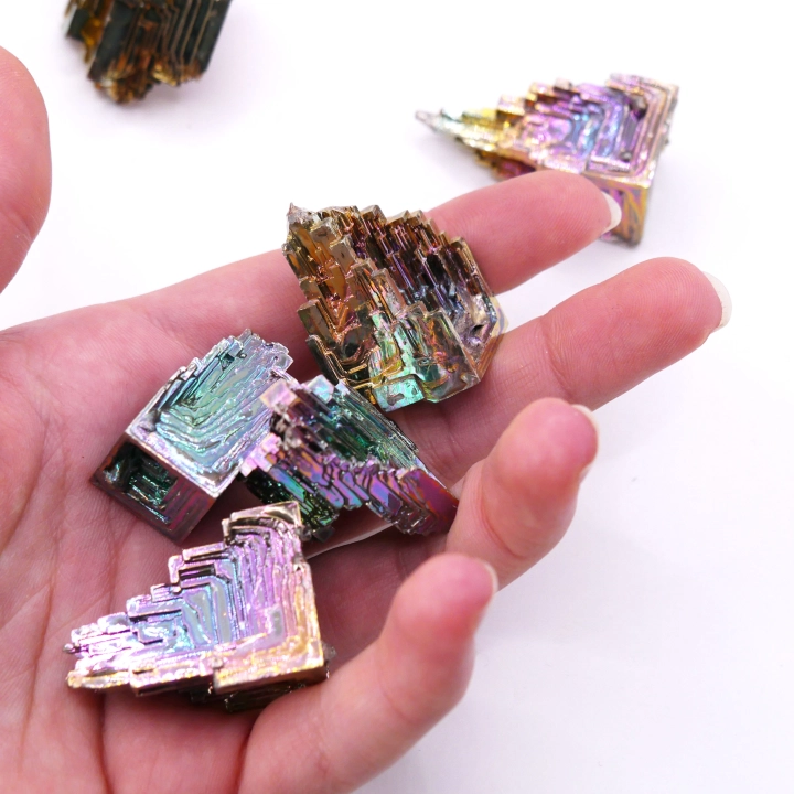 Kryształ bizmutu mieniący się kolorami tęczy – metaliczny połysk i architektoniczna budowa typu hopper.