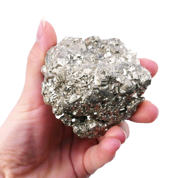 Surowa bryłka pirytu o metalicznym, złotym połysku na białym tle.