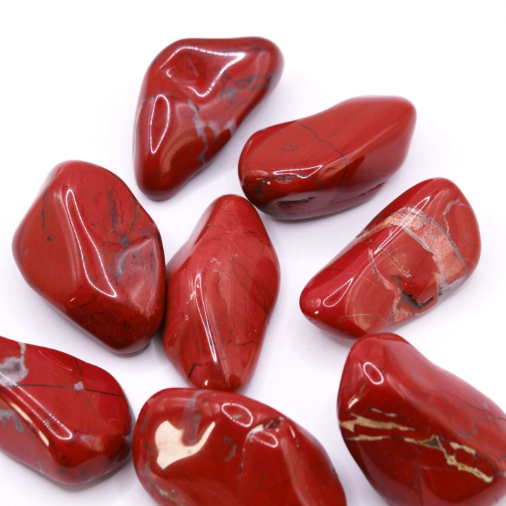 Grupa dużych otoczaków z czerwonego jaspisu, ukazująca naturalne różnice w odcieniach i wzorach.