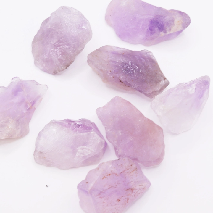 Fioletowy ametyst surowy prezentowany w świetle dziennym – naturalne inkluzje i szkliste refleksy.