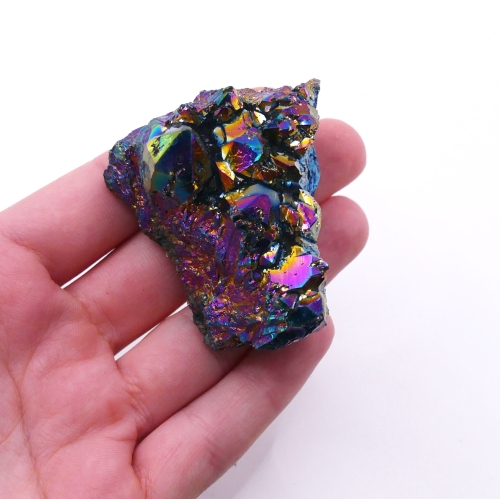 Zbliżenie na metaliczną, iryzującą powierzchnię kryształów ametystu tytanowego.