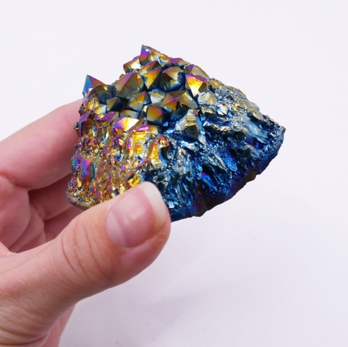 Zbliżenie na metaliczną powłokę kryształów ametystu, mieniącą się wieloma kolorami.