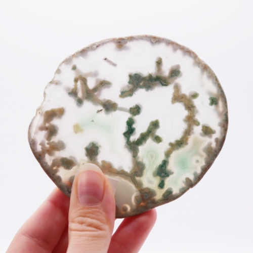 Zbliżenie na zielone pasma i unikalną strukturę wewnątrz plastra agatu nr 064.