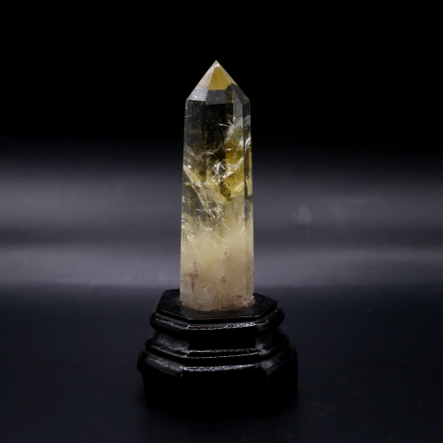 Obelisk z cytrynu na ciemnej drewnianej podstawce – elegancka dekoracja z naturalnego minerału.