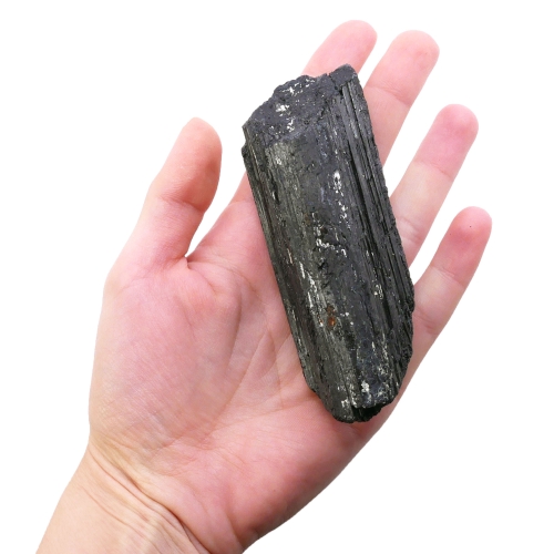 Surowa, nieobrobiona bryłka czarnego turmalinu (szerlu) na białym tle.