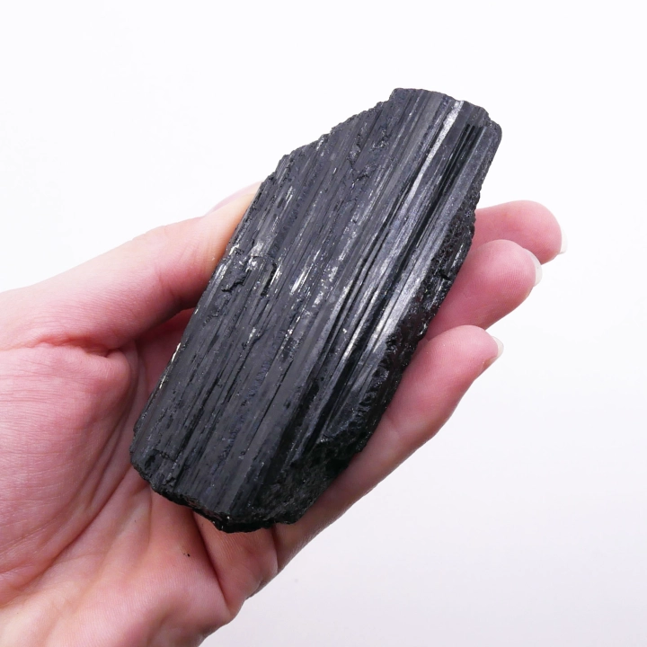 Bryłka turmalinu czarnego – minerał o matowej powierzchni i nieregularnym kształcie