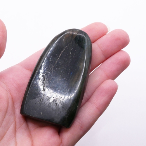 Zjawisko labradorescencji na labradorycie – zbliżenie na metaliczne odcienie i grę światła na powierzchni.