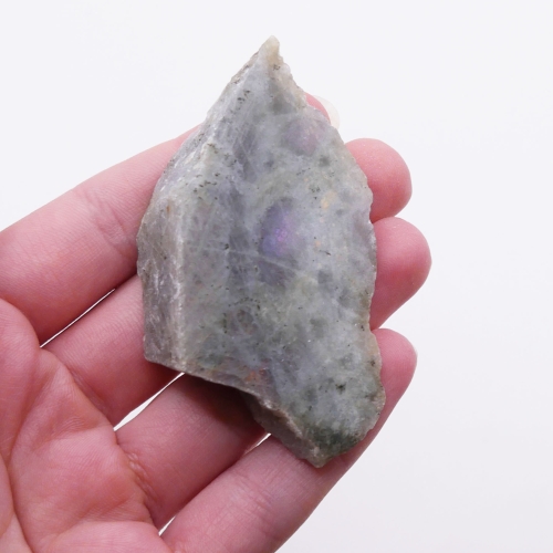 Polerowany front labradorytu mieniący się metalicznym, niebieskim światłem.